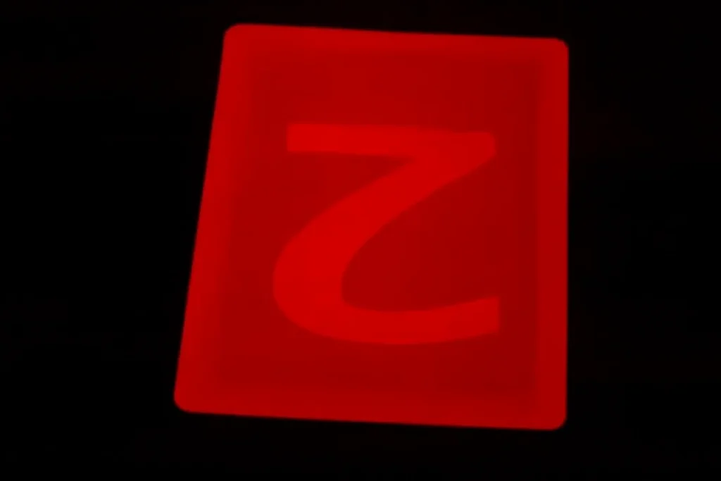 Versoul roșu al cărții de joc strălucește sub lentilele de contact cu infraroșu, dezvăluind clar marcajul luminos ascuns „2” – invizibil cu ochiul liber